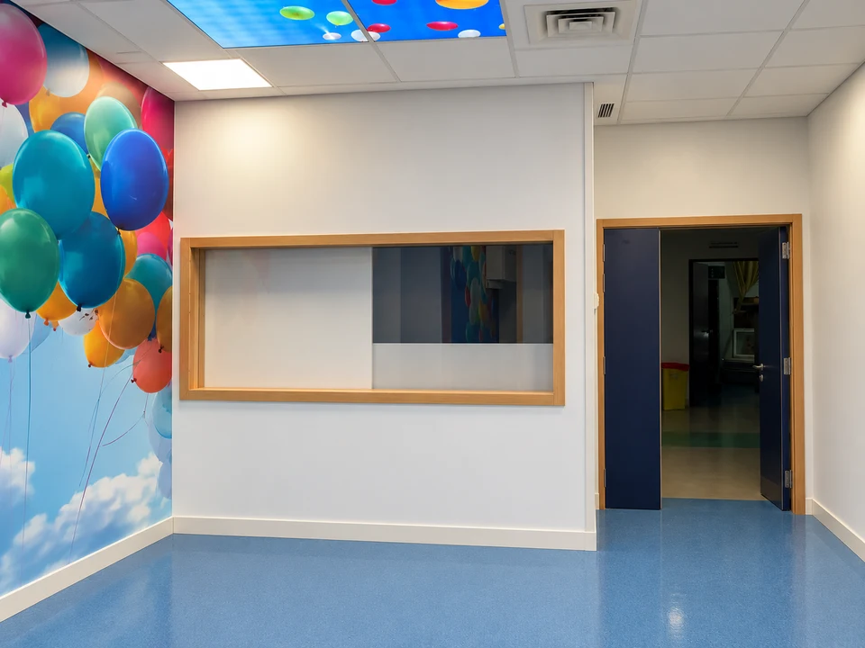 Salle de radiologie pédiatrique du CHU Hassan II de Fès : décor à ballons, vitrage plombé, porte et plafond lumineux