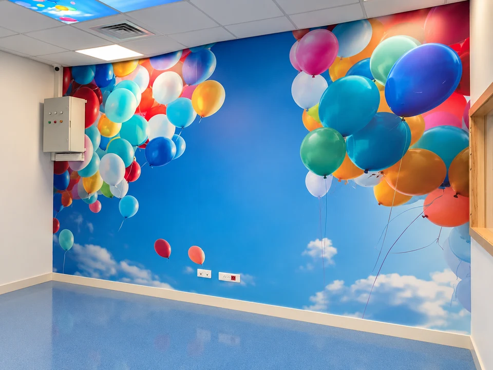Salle de radiologie pédiatrique du CHU Hassan II de Fès : décor mural à ballons, coffret électrique et plafond lumineux